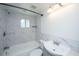 Bathroom with white marble tiled walls, shower and tub combo, and updated fixtures at 117 Roberts Rd, Summerville, SC 29483