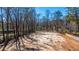 A cleared lot ready for building, surrounded by mature trees under a bright blue sky at 117 Roberts Rd, Summerville, SC 29483