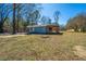 Charming exterior of blue home featuring a cozy wooden porch in a large yard with beautiful trees and a clear blue sky at 117 Roberts Rd, Summerville, SC 29483