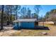 Charming blue exterior home with a cozy wooden porch, surrounded by lush trees and clear sky at 117 Roberts Rd, Summerville, SC 29483