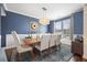 Dining room featuring blue accent wall, elegant chandelier, wood table, and six upholstered chairs at 136 Stagecoach Ln, Summerville, SC 29483