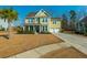 Charming two-story home with green siding, palm tree, and a two-car garage at 136 Stagecoach Ln, Summerville, SC 29483