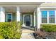 Charming front porch with decorative glass door, white columns, and manicured bushes at 136 Stagecoach Ln, Summerville, SC 29483