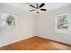 Sunny bedroom with hardwood floors, a ceiling fan, and two windows at 1491 Seacroft Rd, James Island, SC 29412