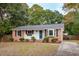Cozy single-story home with a brick and white siding exterior, surrounded by mature trees at 1491 Seacroft Rd, James Island, SC 29412