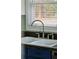 Close-up of a kitchen sink with a modern faucet and a view of the window and backyard at 1491 Seacroft Rd, James Island, SC 29412