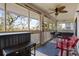 Relaxing screened porch with outdoor seating, a ceiling fan, and views of the surrounding greenery at 2012 Long Bend Drive, Seabrook Island, SC 29455