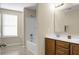 Bright bathroom featuring wood cabinets, double sinks, and a tub with a shower at 212 Medford Dr, Summerville, SC 29485