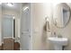 Powder room featuring a pedestal sink with a round mirror and open doorway at 212 Medford Dr, Summerville, SC 29485