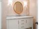 Bathroom vanity with white cabinets, marble countertop, sink, round mirror, and sconces at 2135 Landfall Way, Seabrook Island, SC 29455
