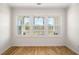 Bright bedroom featuring hardwood floors and a trio of windows with backyard view at 2135 Landfall Way, Seabrook Island, SC 29455