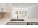 Bright kitchen showcases a stainless steel sink, white countertops, and a view to the spacious living room at 2135 Landfall Way, Seabrook Island, SC 29455
