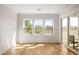 Bright living room features hardwood floors, paneled walls, and sliding door to the balcony, offering outdoor views at 2135 Landfall Way, Seabrook Island, SC 29455