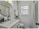 Modern bathroom featuring a sleek vanity, round mirror, contemporary fixtures, and a bright, airy atmosphere at 2218 Dover St, North Charleston, SC 29405