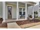 Inviting covered front porch with classic columns, brick flooring, and a cozy seating area at 2425 Giles Ln, Mount Pleasant, SC 29466