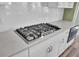 Close up of the gourmet stainless steel range top with white chevron backsplash and sleek white counters at 2425 Giles Ln, Mount Pleasant, SC 29466