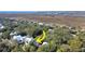 An aerial view of a home nestled in a lush, wooded landscape, featuring white exterior and marsh views at 2514 Myrtle Ave, Sullivans Island, SC 29482