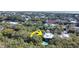 An aerial view of a home nestled in a lush, wooded landscape, featuring a private pool and distant ocean view at 2514 Myrtle Ave, Sullivans Island, SC 29482