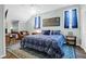 Comfortable bedroom featuring a patterned blue bedspread, blue curtains, and wood floors at 2514 Myrtle Ave, Sullivans Island, SC 29482
