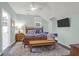 Bedroom with a ceiling fan, a wooden bed, a mounted television, and a wooden bench at 2514 Myrtle Ave, Sullivans Island, SC 29482