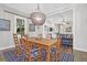 Bright dining room with a beaded chandelier and views of the open living spaces at 2514 Myrtle Ave, Sullivans Island, SC 29482