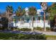Charming two-story home with a welcoming front porch and beautiful palm trees at 2514 Myrtle Ave, Sullivans Island, SC 29482