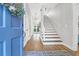 Bright foyer with a blue front door, stairwell and decorative hanging light fixture at 2514 Myrtle Ave, Sullivans Island, SC 29482