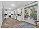 Bright kitchen featuring white cabinets, stainless appliances, hardwood floors with area rugs, and access to outdoor space at 2514 Myrtle Ave, Sullivans Island, SC 29482