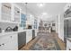 Well-appointed kitchen with white cabinets, stainless steel appliances and wooden floors with area rugs at 2514 Myrtle Ave, Sullivans Island, SC 29482