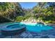 Backyard pool with spa and stone patio, surrounded by lush greenery at 2514 Myrtle Ave, Sullivans Island, SC 29482