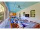 Covered porch with ample seating and entertainment options including a TV with an adjacent dining area at 2514 Myrtle Ave, Sullivans Island, SC 29482