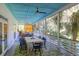 Relaxing screened porch with dining area, blue ceiling, and views of the landscaped yard at 2514 Myrtle Ave, Sullivans Island, SC 29482
