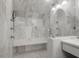 Luxurious marble shower with a built-in bench, multiple showerheads, and glass enclosure at 2514 Myrtle Ave, Sullivans Island, SC 29482