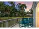 Charming balcony view with teal chairs overlooking lush lawn and mature palm trees, creating a serene outdoor space at 278 Driftwood Ln, Edisto Island, SC 29438