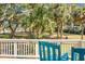 Relaxing balcony view with two blue chairs overlooking a grassy lawn with trees and a golf cart path at 278 Driftwood Ln, Edisto Island, SC 29438