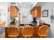 Efficient kitchen with warm wood cabinets, bar seating, and a view into the dining area at 278 Driftwood Ln, Edisto Island, SC 29438