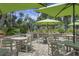 Outdoor patio with seating, umbrellas, and a glimpse of a playground in a lush, tropical setting at 278 Driftwood Ln, Edisto Island, SC 29438