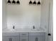 Bright white double vanity with a white marble countertop and a set of modern black lighting fixtures at 2988 Lodge Berry Ln, Johns Island, SC 29455