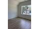 Well-lit bedroom with hardwood flooring, a large window, and neutral walls at 2988 Lodge Berry Ln, Johns Island, SC 29455