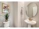 Stylish powder room featuring a pedestal sink, round mirror, and decorative accents at 3092 Emma Ln, Mount Pleasant, SC 29466