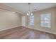 Bright dining room with hardwood floors, neutral walls, a chandelier, a large window and a door at 339 Cicadas Song, Moncks Corner, SC 29461
