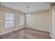 Bright dining room with hardwood floors, neutral walls, a chandelier, and two large windows at 339 Cicadas Song, Moncks Corner, SC 29461