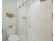 Bathroom featuring walk-in shower, white tile, glass door, and gold hardware and fixtures at 42 Kennedy St, Charleston, SC 29403