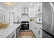 Modern kitchen featuring an island with seating, stainless steel appliances, white cabinetry, and updated lighting at 42 Kennedy St, Charleston, SC 29403