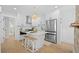 Modern white kitchen featuring an island, stainless steel appliances, pendant lighting, and hardwood floors at 42 Kennedy St, Charleston, SC 29403
