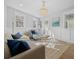 Bright living room with hardwood floors, a beaded chandelier, and large windows with beautiful sunlight streaming in at 42 Kennedy St, Charleston, SC 29403