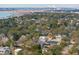 Expansive aerial view showcasing a charming coastal community with lush trees and distant bridge views at 425 Mccants Dr, Mount Pleasant, SC 29464