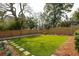Manicured backyard with lush artificial grass, a wooden fence, and stepping stones at 425 Mccants Dr, Mount Pleasant, SC 29464