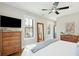 A light and bright primary bedroom with hardwood floors, a ceiling fan, and a TV at 425 Mccants Dr, Mount Pleasant, SC 29464