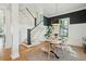 Stylish dining area with a modern chandelier, a staircase, and a white and black color palette at 425 Mccants Dr, Mount Pleasant, SC 29464